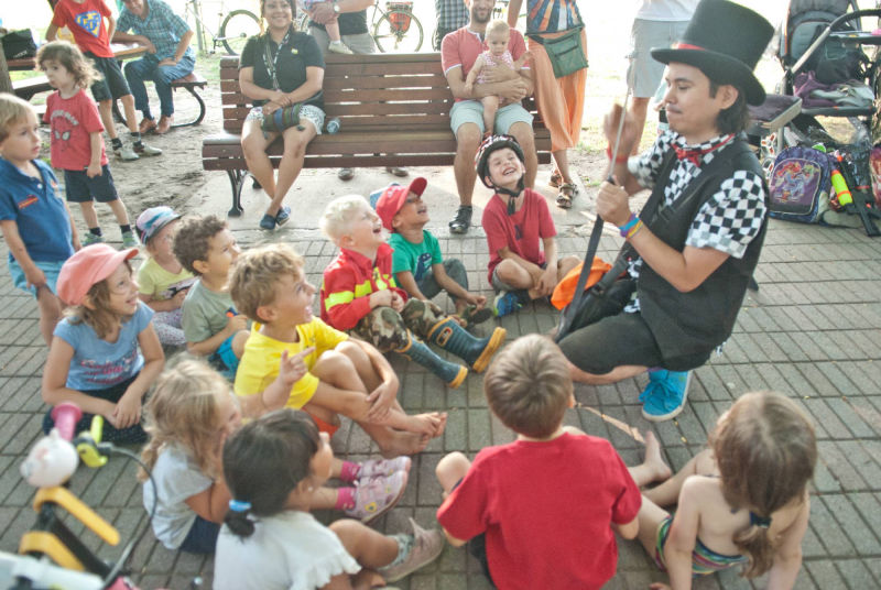Yan le magicien dans un parc avec 12 enfants qui rient
